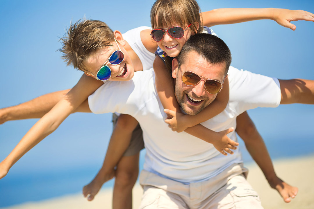 Father with children having fun on the beach at the day time.