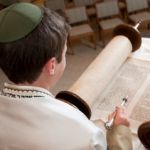 Young man reading from the Torah scroll