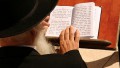 An Orthodox Jewish man reads from the siddur (prayer book) at the Western (Wailing) Wall
