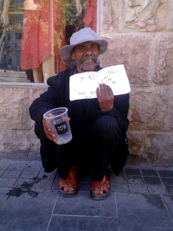 A homeless man begs on the street in Israel.