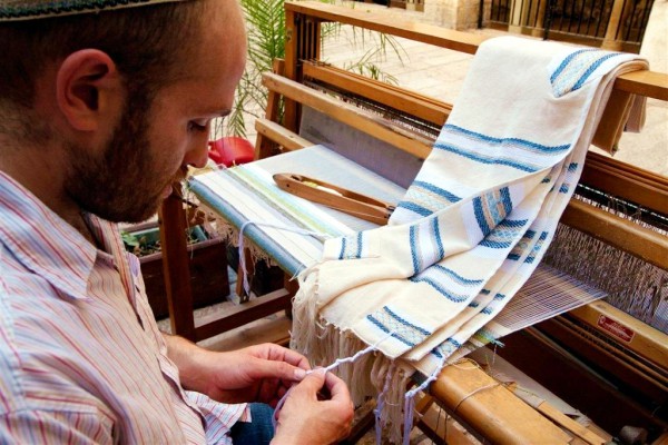 A Jewish artisan who weaves tallitot ties the tzitzit to the four corners of the garment. (Israel photo gallery by Noam Chen)