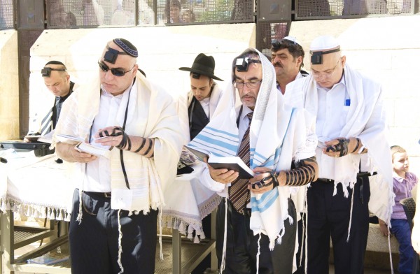 Jewish men wearing tallitot pray at the Western (Wailing) Wall in Jerusalem.