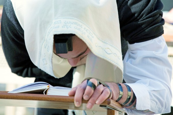 A Jewish man prays Shacharit (morning prayer) at the Western Wall (Kotel or Wailing Wall) in Jerusalem.