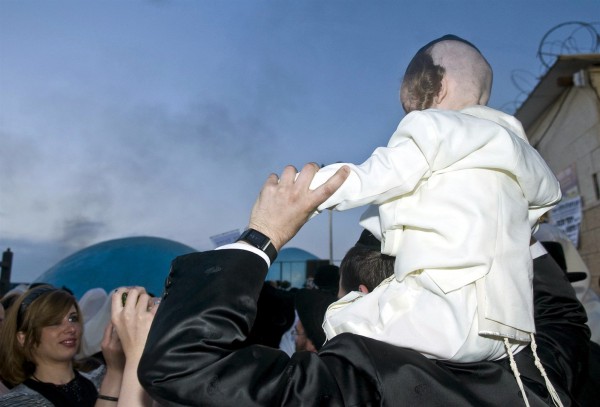 A three-year-old boy wears a tallit katan under his shirt.