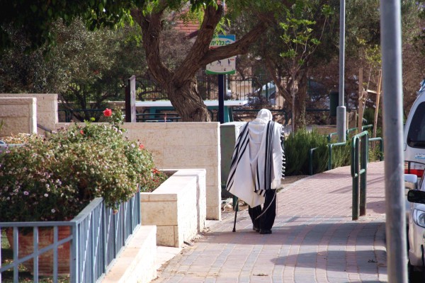 A Jewish man walks home from morning prayers in Israel. (Flickr photo by Avital Pinnick)