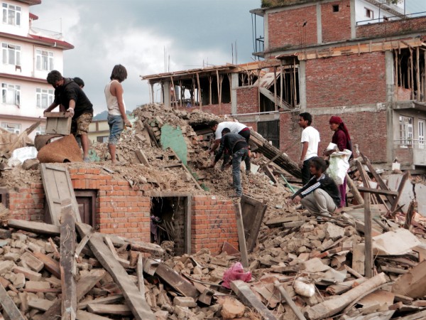 People rummage through the ruins of their home following the earthquake in Nepal.  (Photo by SIM Central and Southeast Asia)