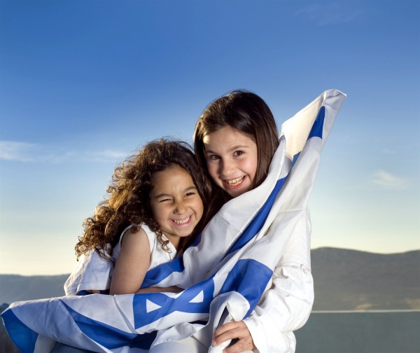 Two Israeli girls hold the Israeli flag.