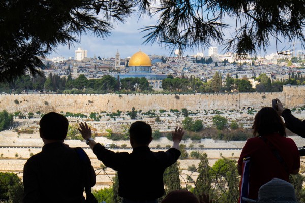 A Christian tourist on the Mount of Olives prays for the peace of Jerusalem.