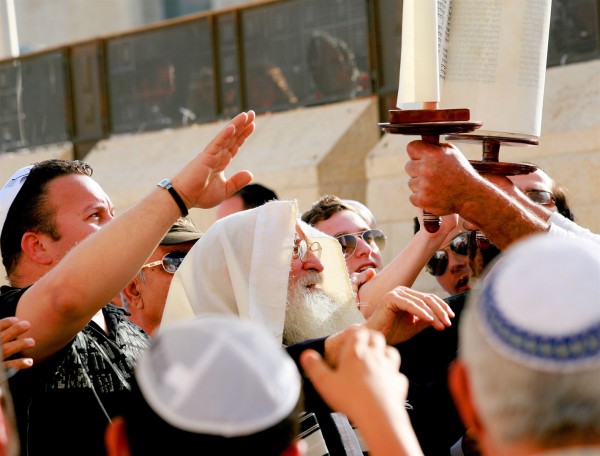 Jewish men pay respect to the Torah scroll at the Western (Wailing) Wall.