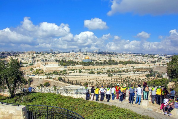 Tourists on the Mount of Olives look toward the Temple Mount where the First and Second Jewish Temples once stood in Jerusalem.