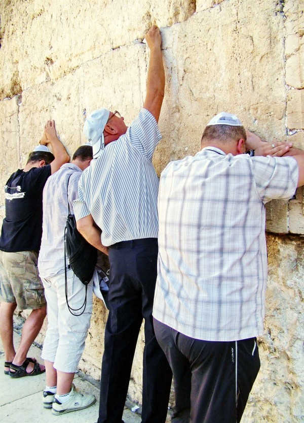 Jewish men pray at the Western (Wailing) Wall in Jerusalem, where it is traditional to stuff prayers on slips of papers in the crevices of the wall.