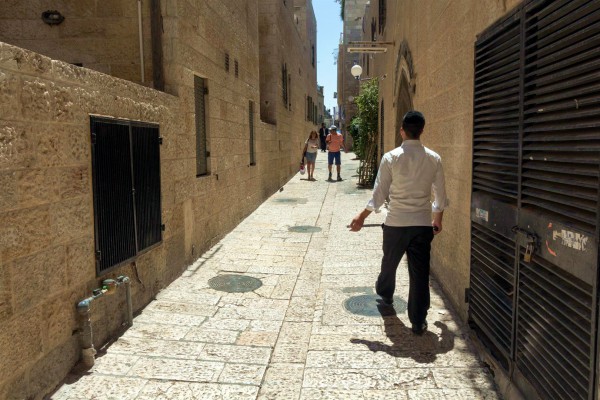 People walk down a narrow street in the Old City of Jerusalem.