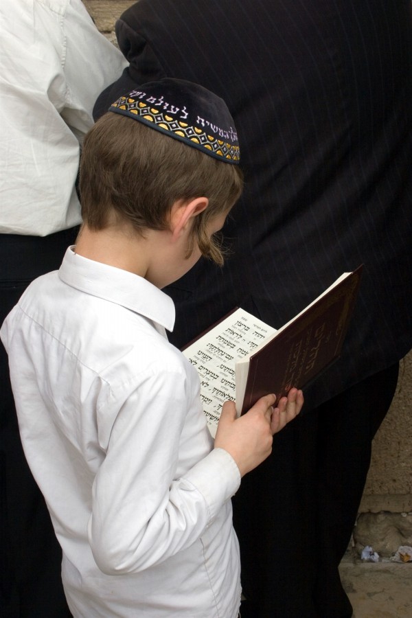 A Jewish boy reads the Jewish prayer book at the Western (Wailing) Wall.