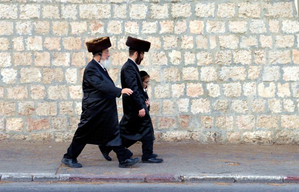 Two Jewish men and a boy walk together in Israel.