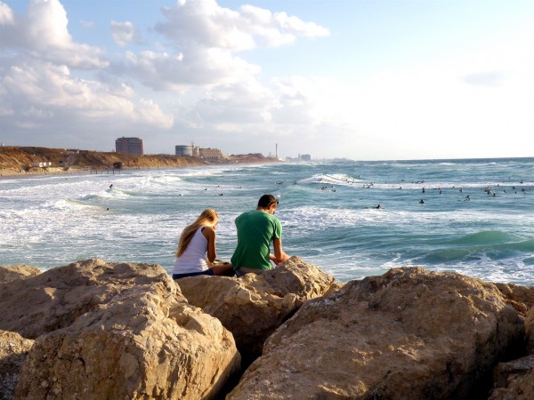 An Israeli couple sits by the Mediterranean Sea. (Photo by Ron Almog)