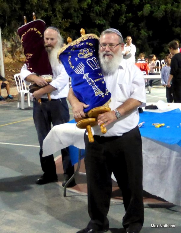 It is considered a mitzvah (good deed) to dance with the Torah and to rejoice over it on Simchat Torah. (Photo by Max@Nathans)