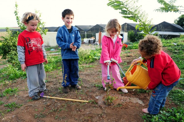 Israeli children water a tree they just planted in honor of Tu B'Shvat.